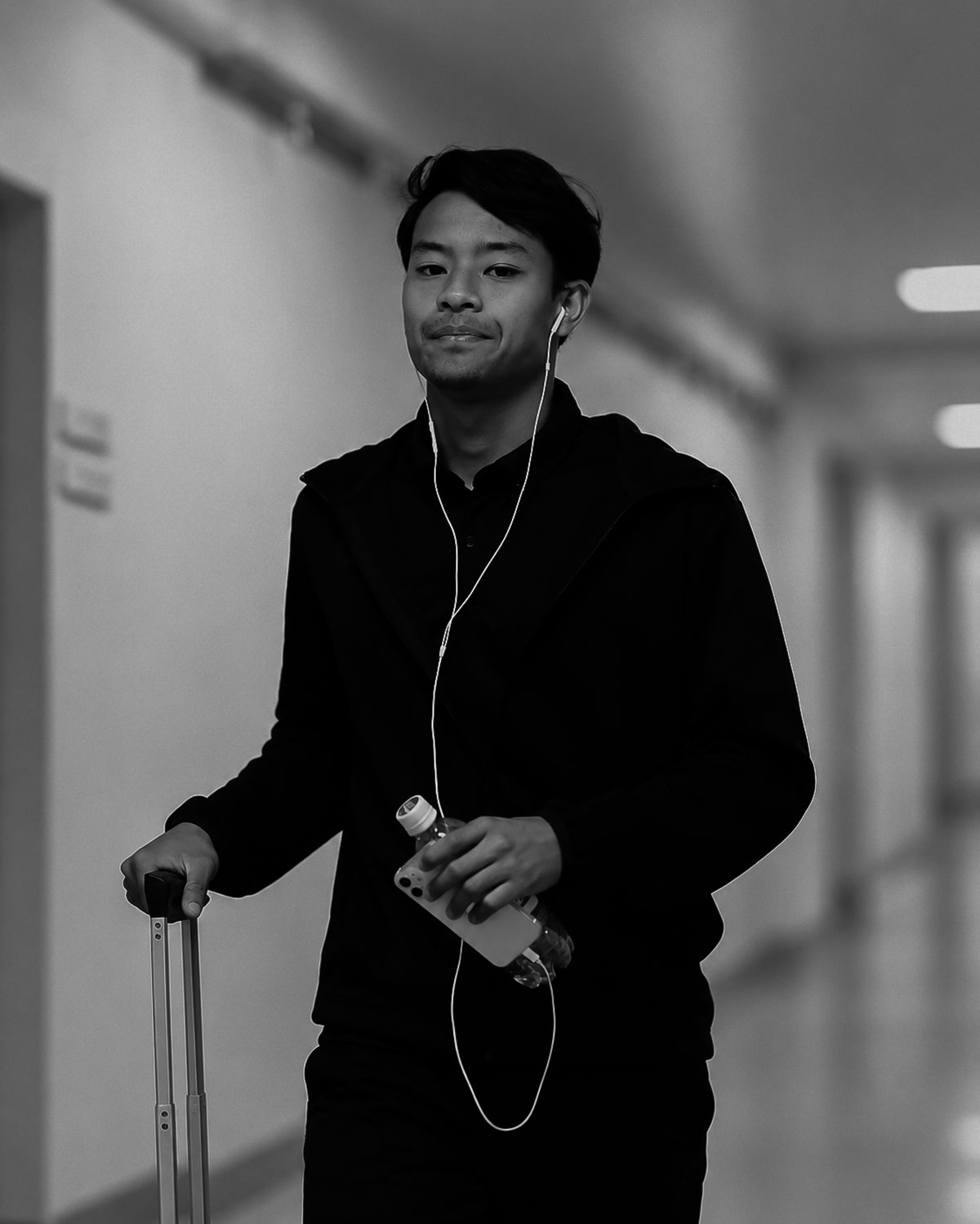 Luqman Hakim, pro footballer, walking with a suitcase